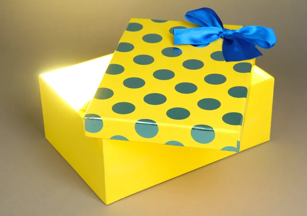 Geschenkbox mit hellem Licht auf grauem Hintergrund — Stockfoto