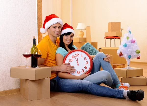 Casal jovem com caixas em nova casa celebrando o Ano Novo — Fotografia de Stock