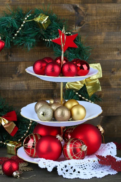 Christmas decorations on dessert stand, on wooden background — Stock Photo, Image