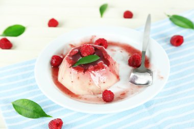 Panna cotta ahşap zemin üzerinde frambuaz sos ile