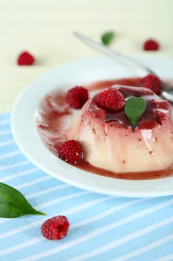 Panna cotta ahşap zemin üzerinde frambuaz sos ile