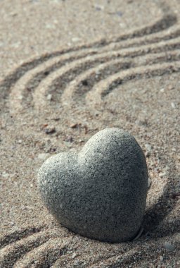 Gri zen stone kum arka plan üzerinde kalp şeklinde