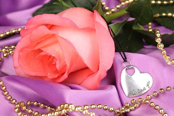 Belle rose rose avec pendentif coeur — Photo