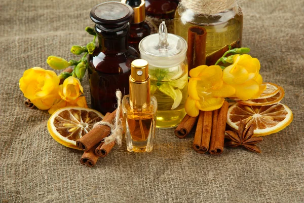 Flessen met ingrediënten voor het parfum op jute achtergrond — Stockfoto