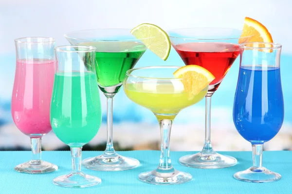 Glasses of cocktails on table near pool — Stock Photo, Image