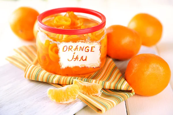 Sinaasappeljam met schil en mandarijnen, op witte houten tafel — Stockfoto