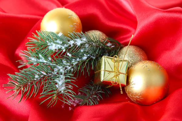 Красивый рождественский декор на красной атласной ткани — стоковое фото