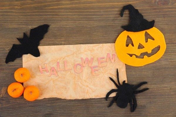 Old paper with Halloween decorations on grey wooden background — Stock Photo, Image