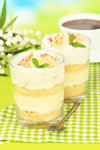 Delicioso postre con plátano y caramelo en la mesa sobre fondo brillante — Foto de Stock