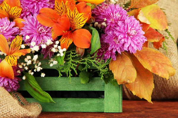 Composição de flores em caixa na mesa sobre fundo de pano de saco — Fotografia de Stock