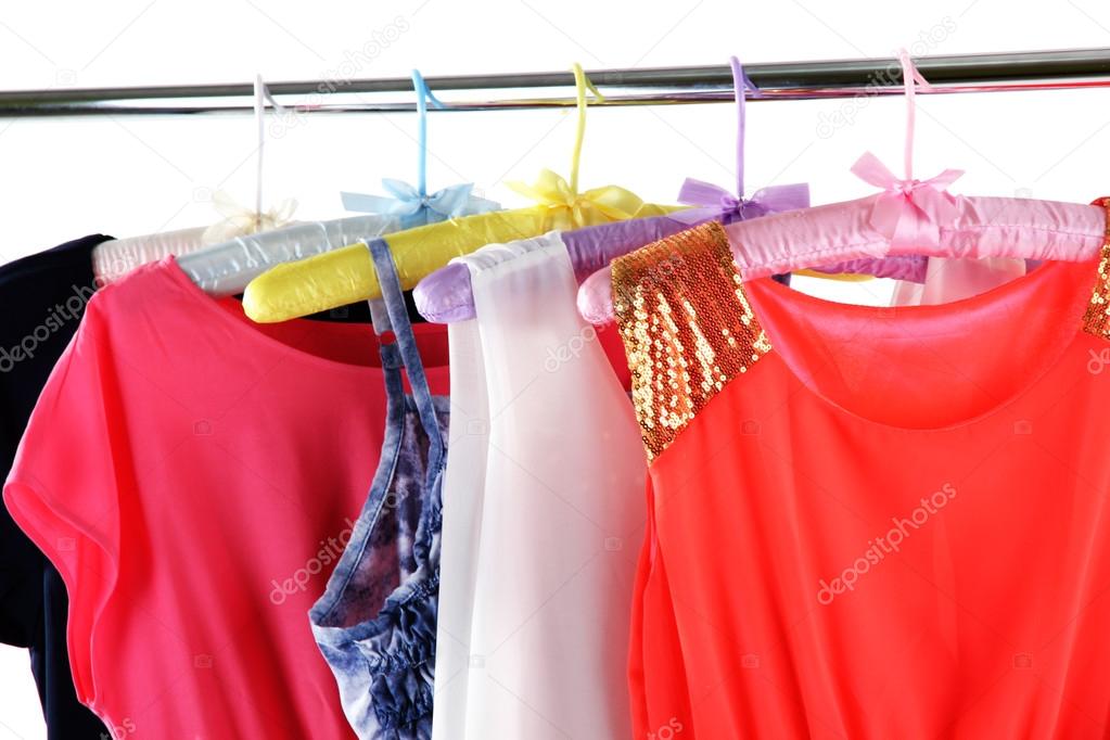 Beautiful dresses hanging on hangers isolated on white