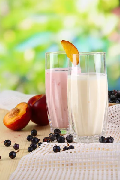 Pyszne koktajle mleczne z blackberry i brzoskwinia na drewnianym stole na naturalne tło — Zdjęcie stockowe