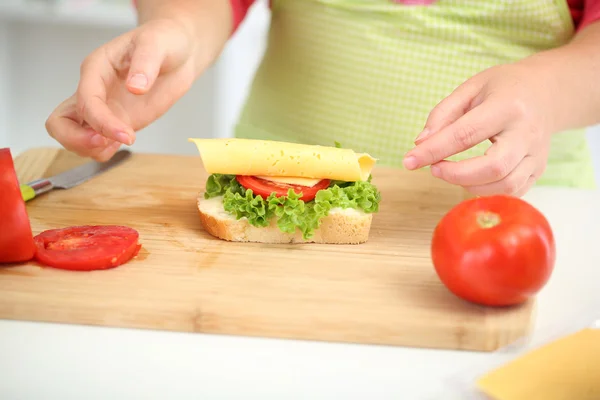 Happy smiling woman in kitchen preparing sandwich, close up — Stock Photo, Image