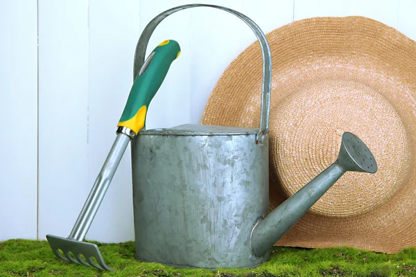 Gartengeräte auf Gras auf Holzgrund — Stockfoto