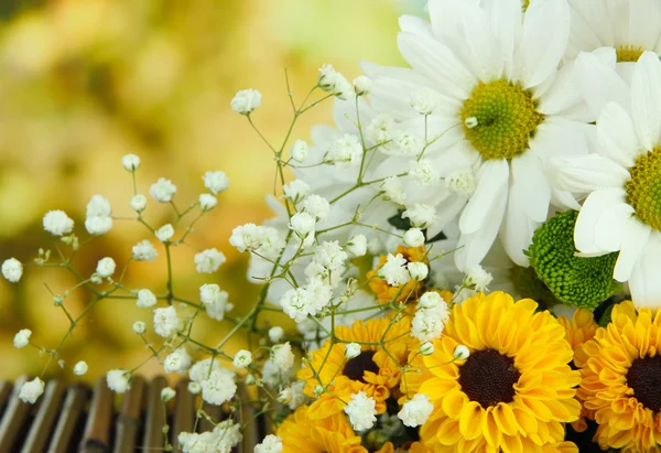 Bellissimi fiori sul tavolo su sfondo luminoso — Foto Stock