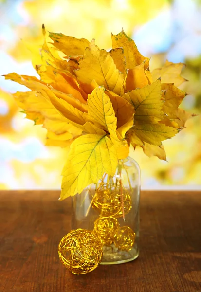 Feuilles d'automne lumineuses dans un vase sur une table en bois sur fond naturel — Photo
