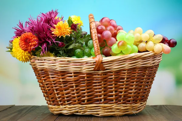 Schöne Blumen in Weidenkorb auf hellem Hintergrund — Stockfoto