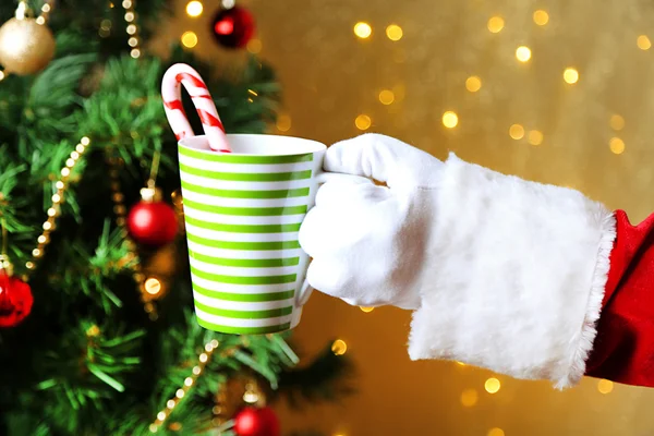 Santa holding mug in his hand, on bright background — Stock Photo, Image