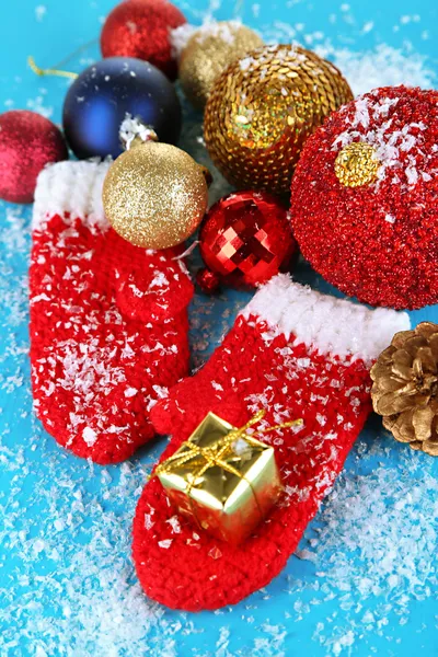 Mitenes de inverno vermelho com brinquedos de Natal na mesa de madeira azul — Fotografia de Stock