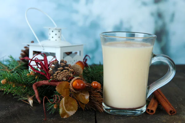 Coupe de lait de poule avec branches de sapin et décorations de Noël sur table sur fond lumineux — Photo