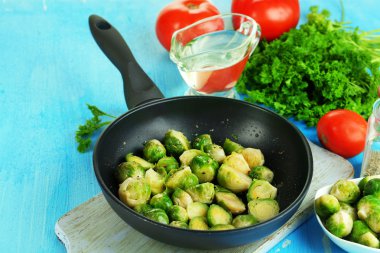 ahşap masa yakın çekim üzerinde baharat ve sebzeler ile tavada taze Brüksel lahanası