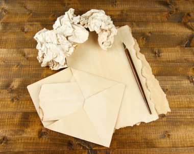 Tükenmez kalem ve zarflar ahşap zemin üzerinde buruşuk kağıt topları