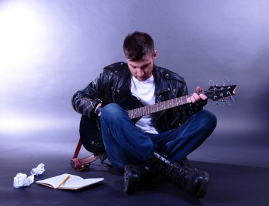 genç müzisyen gri arka plan üzerinde gitar çalmak