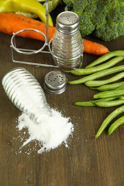 Composición de molinos de sal y pimienta y verduras frescas, sobre fondo de madera — Foto de Stock