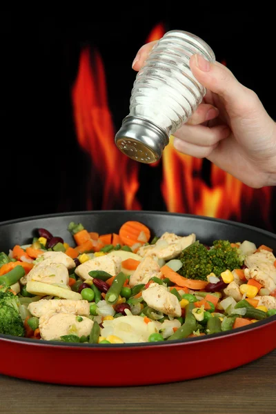 Cazuela con verduras y carne en la sartén, sobre fondo de fuego — Foto de Stock