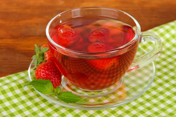 Delicious strawberry tea on table close-up