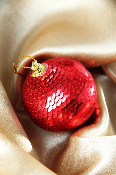Hermosa bola de Navidad en tela de satén dorado — Foto de Stock