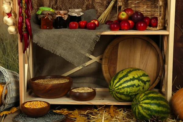 Fruits and vegetables with jars of jam and bowls of grains on shelves close up — Stock Photo, Image