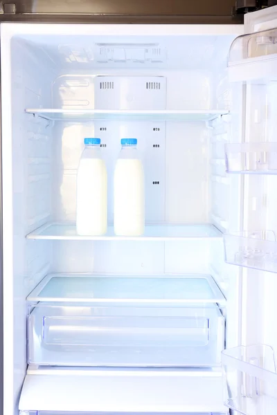 Bottles with milk in refrigerator — Stock Photo, Image