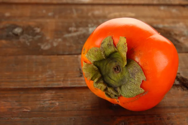 Rijp persimmon op houten achtergrond — Stockfoto