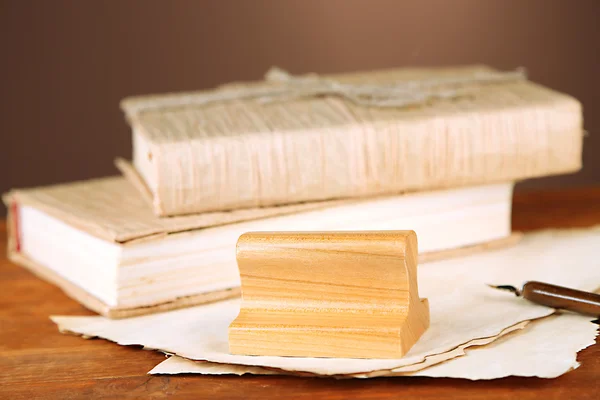 Wooden stamp, books and old papers on wooden table — Stock Photo, Image