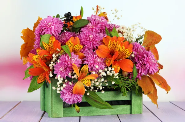 Composition des fleurs dans la caisse sur la table sur fond lumineux — Photo