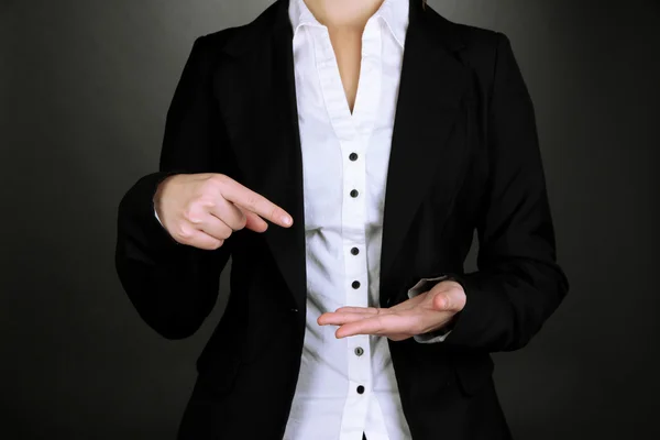 Female hands showing something on grey background — Stock Photo, Image