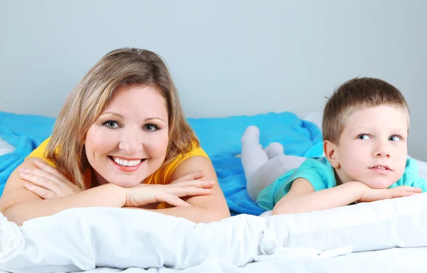 Little boy with mom lying in bed — Stock Photo, Image