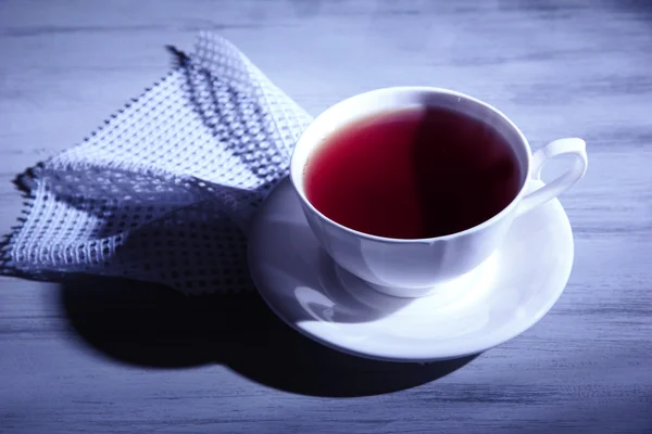 Tasse Heißgetränk auf Holztischhintergrund, bei dunkler Beleuchtung — Stockfoto