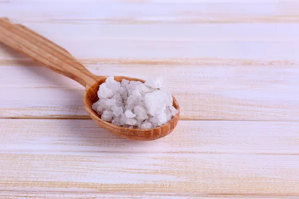 Cuchara de madera con sal marina, sobre fondo de madera de color — Foto de Stock