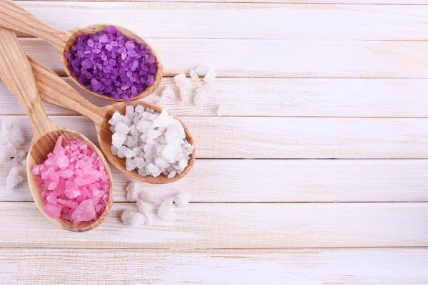 Wooden spoons with sea salt, on color wooden background — Stock Photo, Image