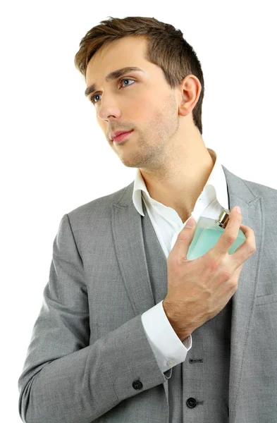 Bonito jovem usando perfume isolado no branco — Fotografia de Stock