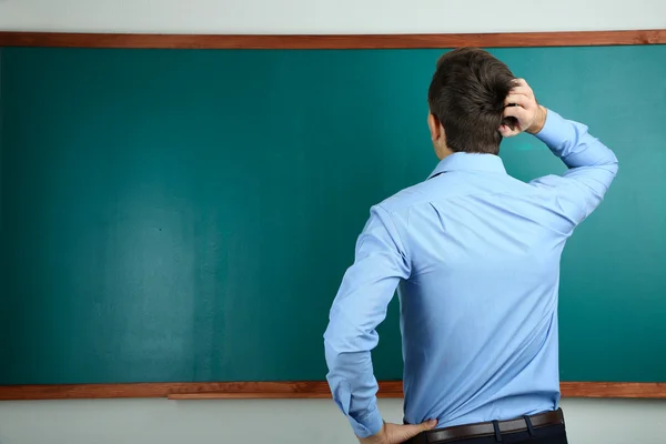 Unga lärare nära svarta tavlan i skolan klassrum — Stockfoto