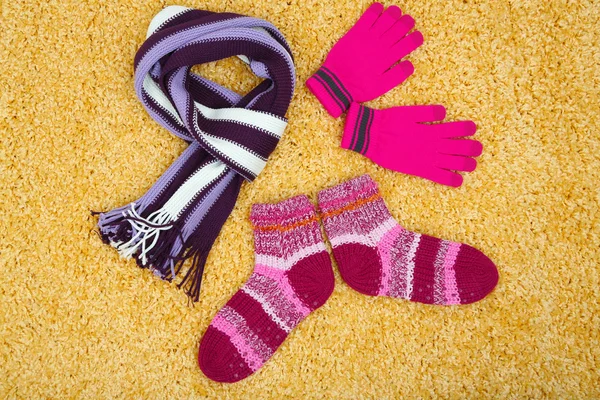 Winter scarf, gloves and socks, on color background — Stock Photo, Image