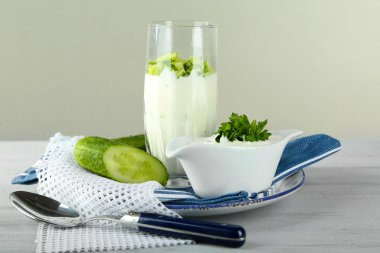 cam, tahta masada gri arka plan üzerinde renkli peçete üzerinde salatalık yoğurt