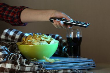 birisi cips ve cola odasında tv izliyor