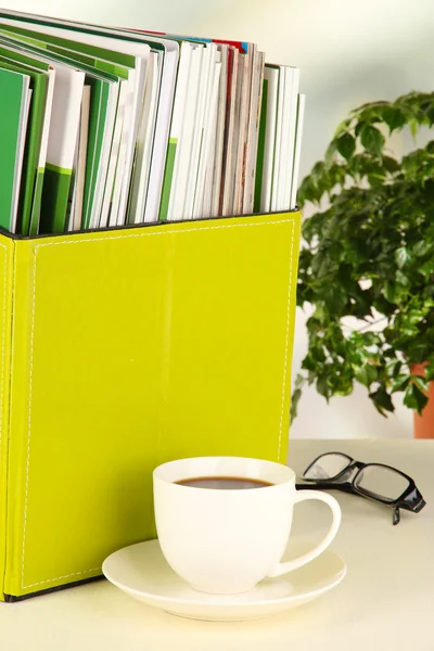Czasopisma i foldery w zielonym polu, na tle wnętrza biura — Zdjęcie stockowe