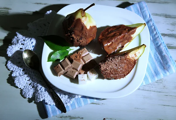 Peçete ahşap masa üzerinde plaka üzerinde çikolata armut — Stok fotoğraf