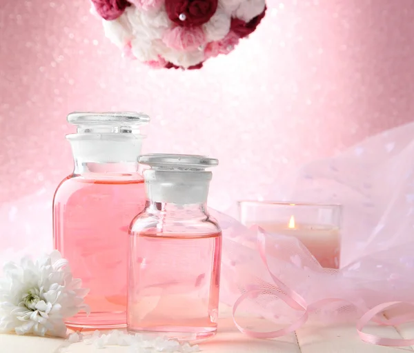 Botellas de vidrio con esencia de color, sobre fondo rosa —  Fotos de Stock
