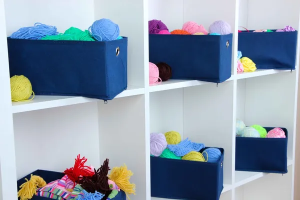 Blue textile boxes with yarn in white shelves — Stock Photo, Image